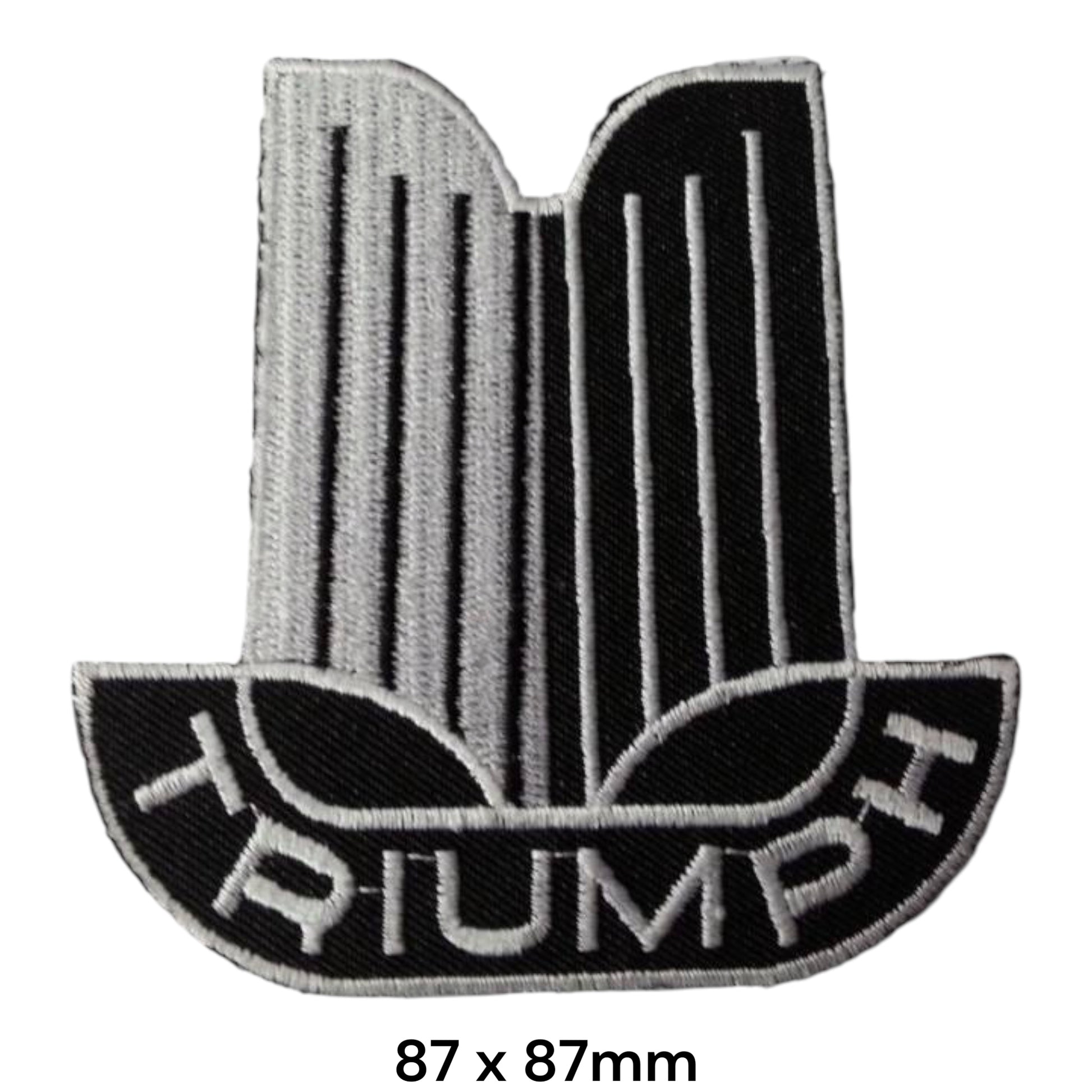 Triumph Classic Eagle Crest Embroidered Patch 87x87mm – silver & black classic Triumph crest with eagle/wing motif, vertical pin-stripe detail and white Triumph block lettering on black semicircular base